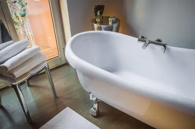 a white bath tub in a bathroom with a chair at Frattina 57 in Rome
