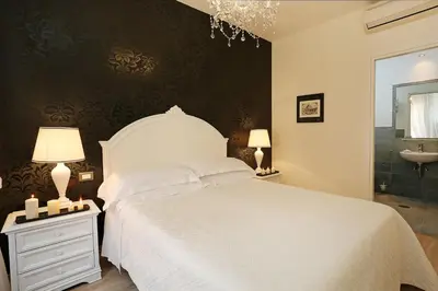 a bedroom with a white bed and a sink at Daplace - HQH Colosseo in Rome