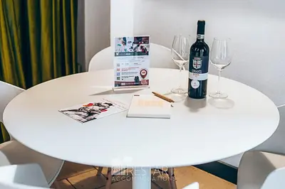 a white table with a bottle of wine and glasses at Restart Accommodations Ada in Rome