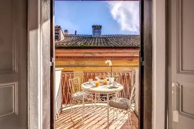 an open door to a balcony with a table and chairs at Maison Babuino in Rome