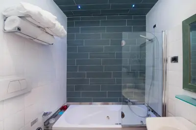 a bathroom with a tub and a shower and a sink at Relais Forus Inn in Rome
