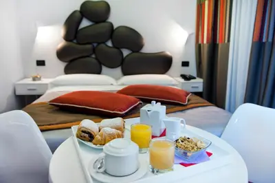 a bed with a tray of food on a table at Relais Forus Inn in Rome