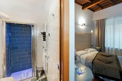 a bathroom with a shower and a bedroom with a bed at Relais Forus Inn in Rome