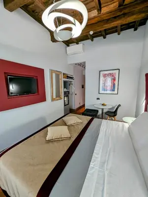 a large bed in a room with a red wall at Relais Forus Inn in Rome