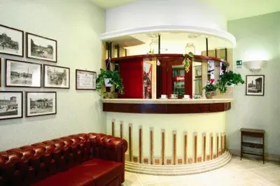 a waiting room with a couch and a mirror at Hotel Demetra Capitolina in Rome