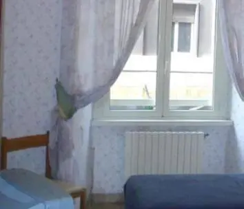 a bedroom with a window and a blue bed and a radiator at Hotel Demetra Capitolina in Rome