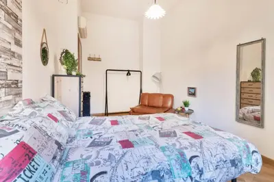 a bedroom with a bed and a chair at Re Di Roma Vintage Apartment in Rome