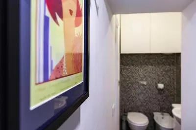 a bathroom with two toilets and a painting on the wall at Casa Paola Guesthouse in Rome