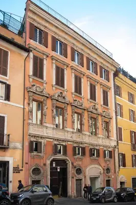 a large brick building with cars parked in front of it at Casa Paola Guesthouse in Rome