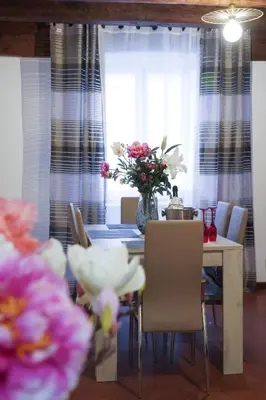 a dining room with a table and a vase of flowers at Navona Jacuzzi Apartment in Rome