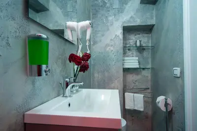 a bathroom with a white sink with a red rose at Navona Jacuzzi Apartment in Rome
