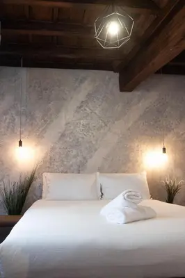 a bedroom with a white bed with two lights at Navona Jacuzzi Apartment in Rome