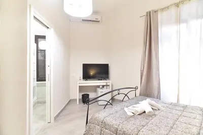 a white bedroom with a bed and a television at GuestHouse o Affittacamere Magenta Baylon Suite B in Rome