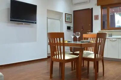 a dining room table with two chairs and a television at Casa di Alberta in Rome