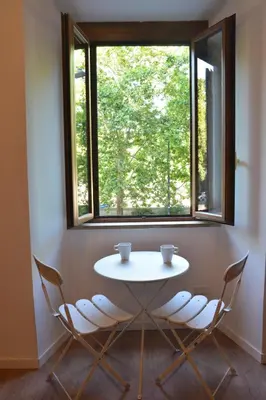 a white table and chairs in a room with a window at All You Need is Rome Guesthouse in Rome