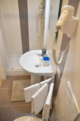 a bathroom with a sink and a toilet and a mirror at All You Need is Rome Guesthouse in Rome