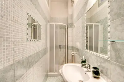 a white bathroom with a sink and a mirror at Finally in Rome in Rome