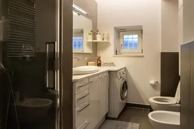 a bathroom with two sinks and a washing machine at La Casupola - Gemelli Garden in Rome