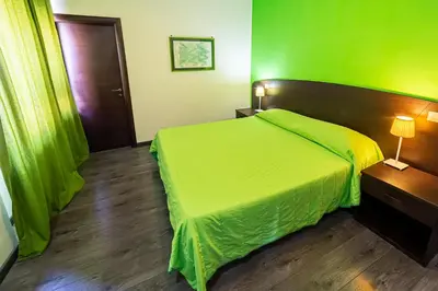 a bedroom with a green bed and a wooden floor at Difronte Ai Musei Vaticani in Rome