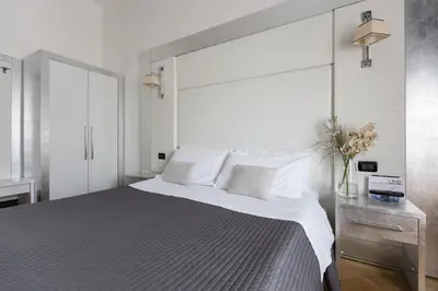 a white bedroom with a large bed with white pillows at Residenza Scipioni Luxury B&B in Rome
