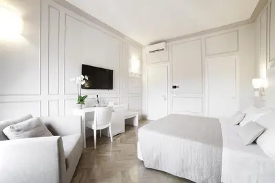 a white bedroom with a bed and a table at Residenza Scipioni Luxury B&B in Rome