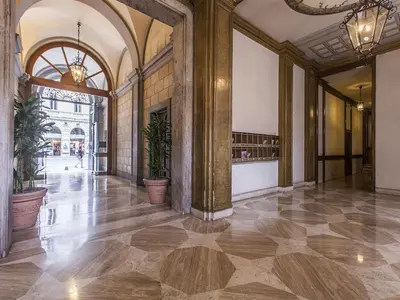 a hallway of a building with a lobby with potted plants at Hotel Regina Giovanna in Rome