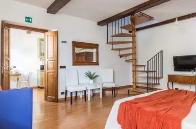 a bedroom with a staircase and a living room at Torripa Group - Trastevere in Rome