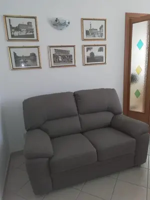 a couch in a living room with pictures on the wall at Casa SereTina in Rome