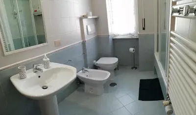 a white bathroom with a sink and a toilet at Casa SereTina in Rome