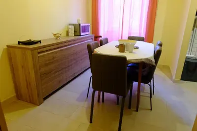 a dining room with a table and chairs and a microwave at Villa Ella in Rome