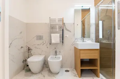 a white bathroom with a toilet and a sink at Concept Terrace Hotel in Rome