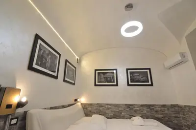a bedroom with a bed and pictures on the wall at Popolo Relax in Rome