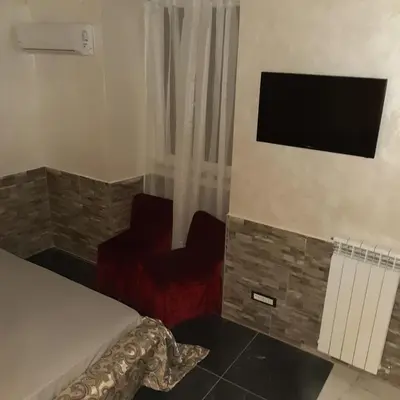 a room with a bed and a tv and a chair at Popolo Relax in Rome