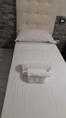 a white bed with two towels on it at Popolo Relax in Rome