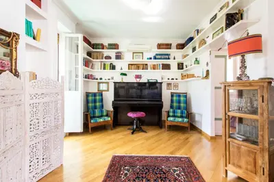 a living room with white walls and a piano at Rome Top floor with Terrace in Rome