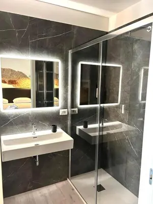a bathroom with a sink and a glass shower at Inn Urbe Colosseo in Rome