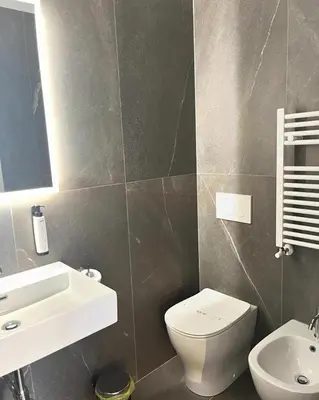 a bathroom with a white toilet and a sink at Inn Urbe Colosseo in Rome