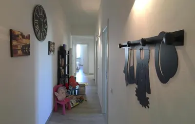 a hallway with a clock on the wall and some toy guns at GARBATELLA'S in ROME in Rome
