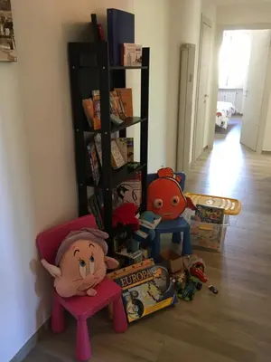a room with a book shelf with books and toys at GARBATELLA'S in ROME in Rome
