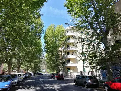 a street with cars parked in front of a building at GARBATELLA'S in ROME in Rome