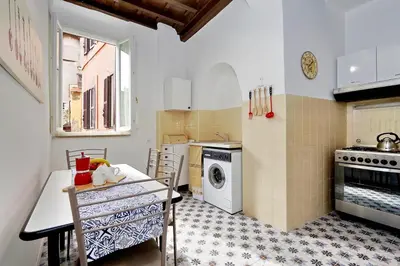 a kitchen with a table and a washing machine at Pellegrino in Rome