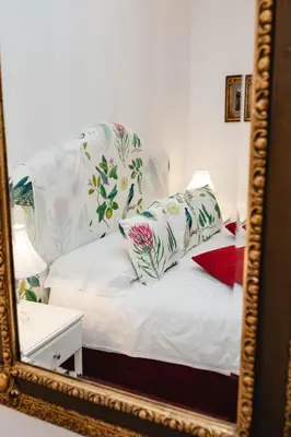 a mirror reflection of a bed with pillows on it at Delfini Trevi House in Rome