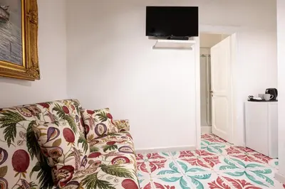a living room with a couch and a flat screen tv at Delfini Trevi House in Rome
