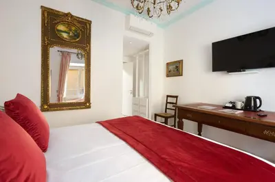 a bedroom with a bed and a desk and a television at Delfini Trevi House in Rome