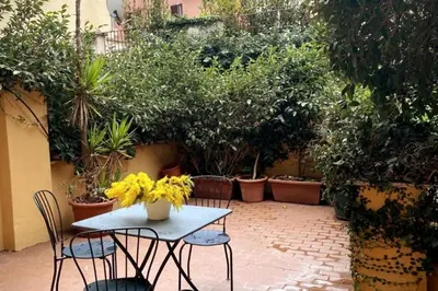 a patio with a table and chairs and plants at Central quiet apartment and terrace in Rome