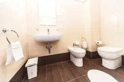 a bathroom with a sink and a toilet and a mirror at Central quiet apartment and terrace in Rome