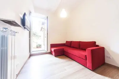 a red couch in a room with a window at Central quiet apartment and terrace in Rome