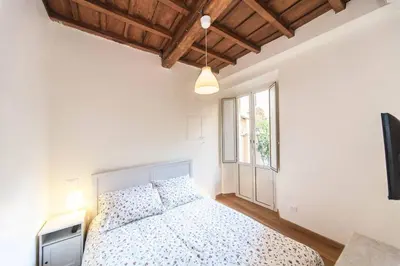 a white bedroom with a bed and a window at Central quiet apartment and terrace in Rome