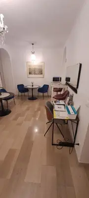 a room with tables and chairs and a table with books at Casa Linnea in Rome