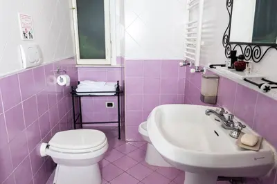 a purple bathroom with a toilet and a sink at Casa Linnea in Rome